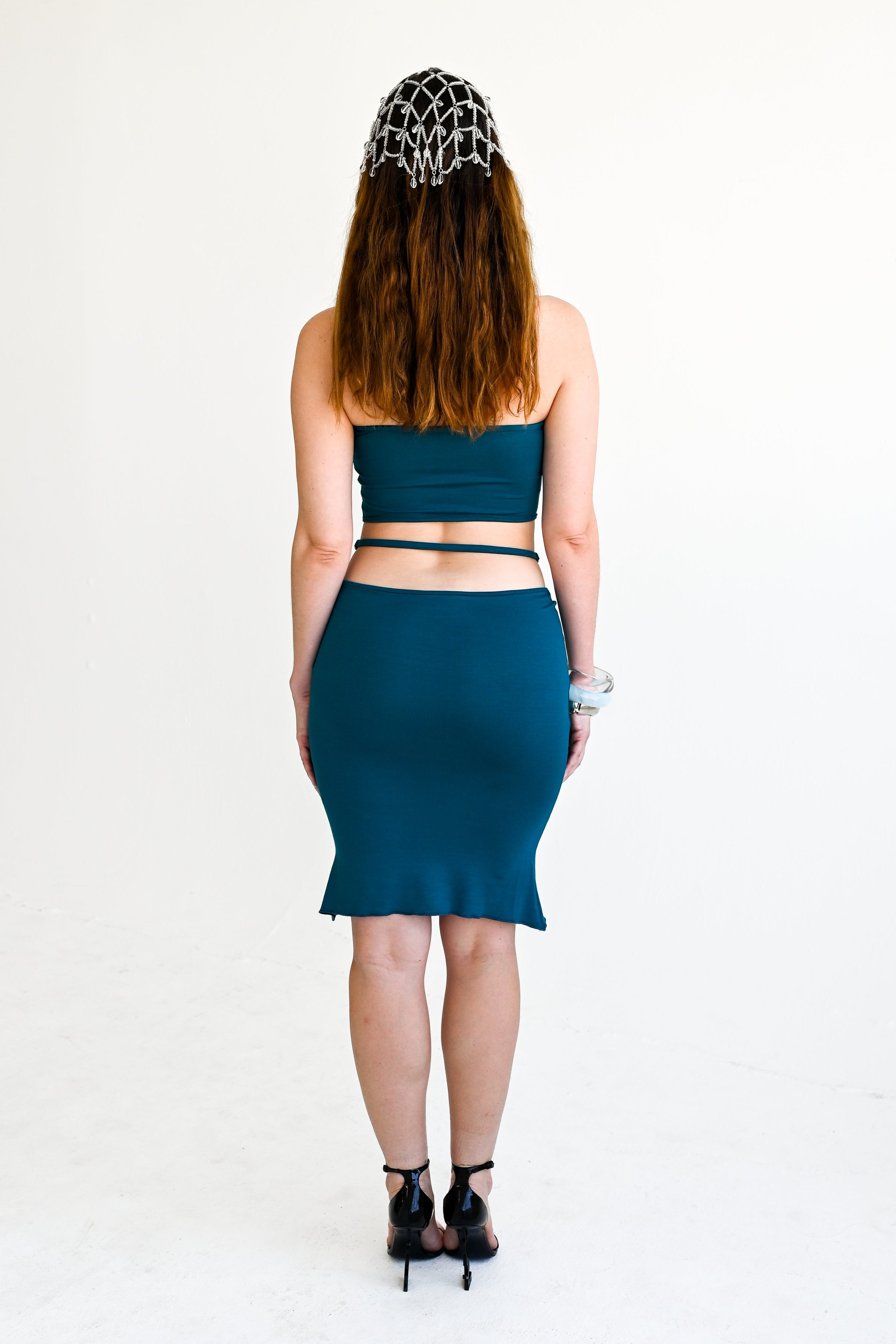 Woman wearing a teal outfit with a white background
