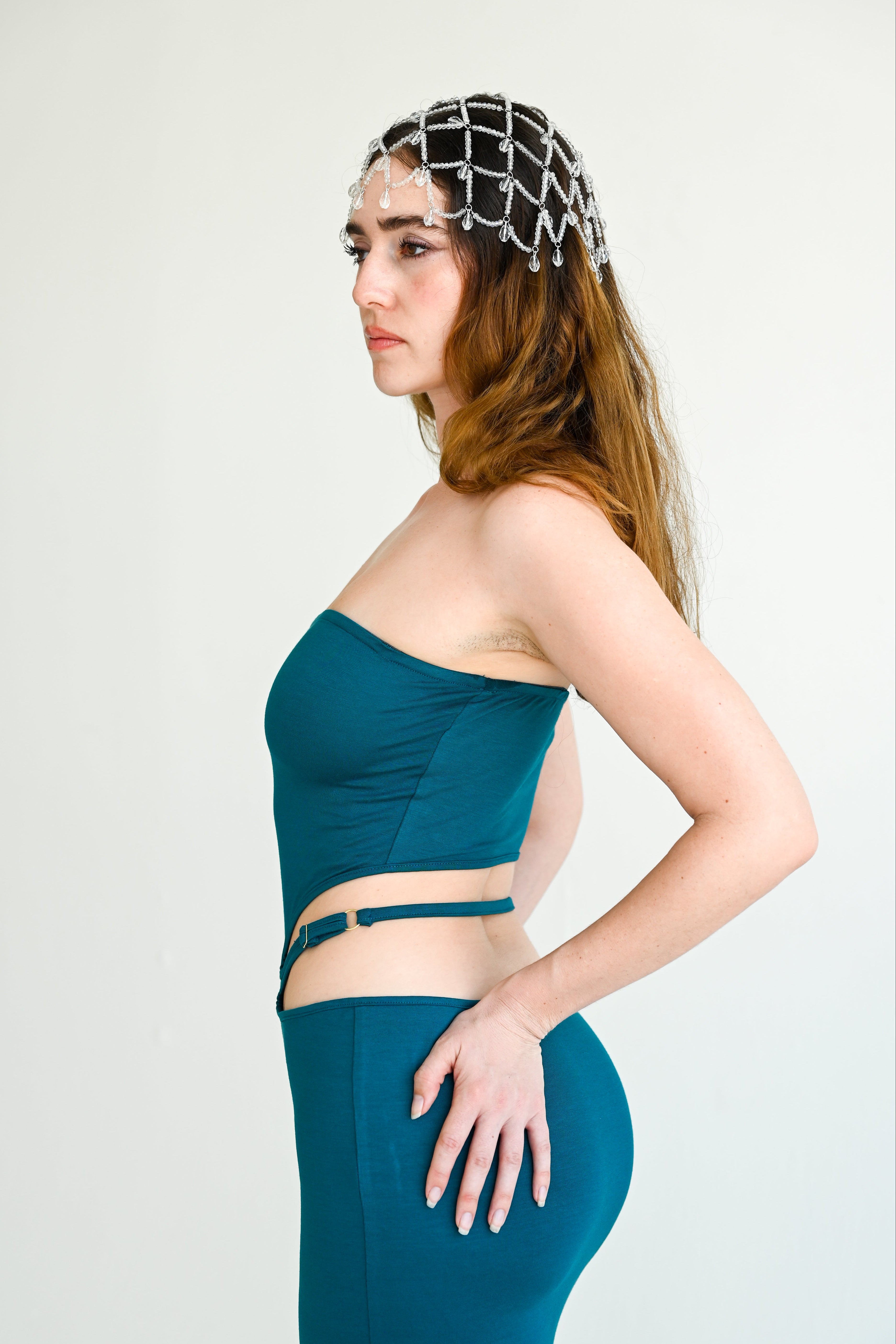 Woman wearing a teal outfit with a white background